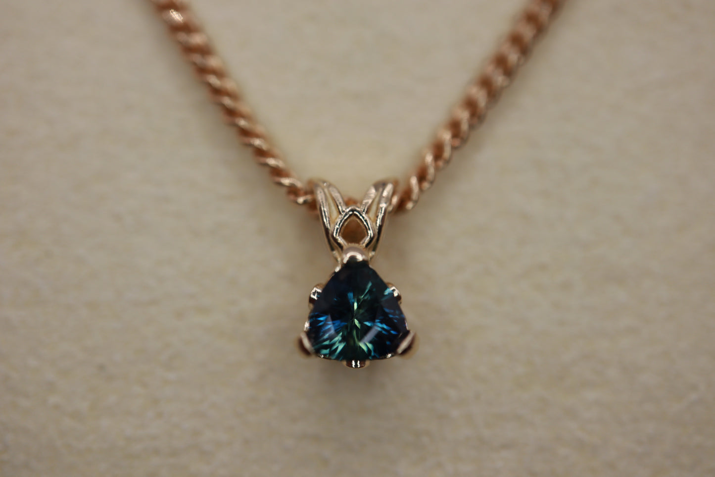 14k gold pendant with a sapphire setting